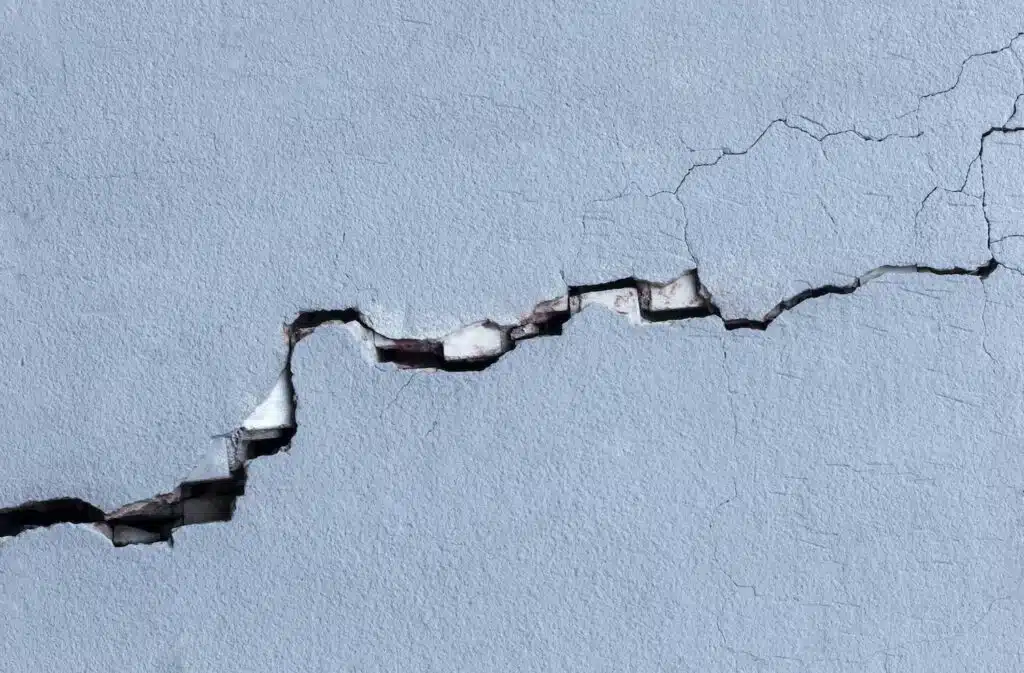 Knoxville homeowner inspecting signs of foundation problems including wall cracks and structural damage