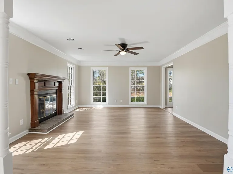 Newly renovated living room featuring oakwood fireplace and french floor to ceiling windows in light wooden flooring. 