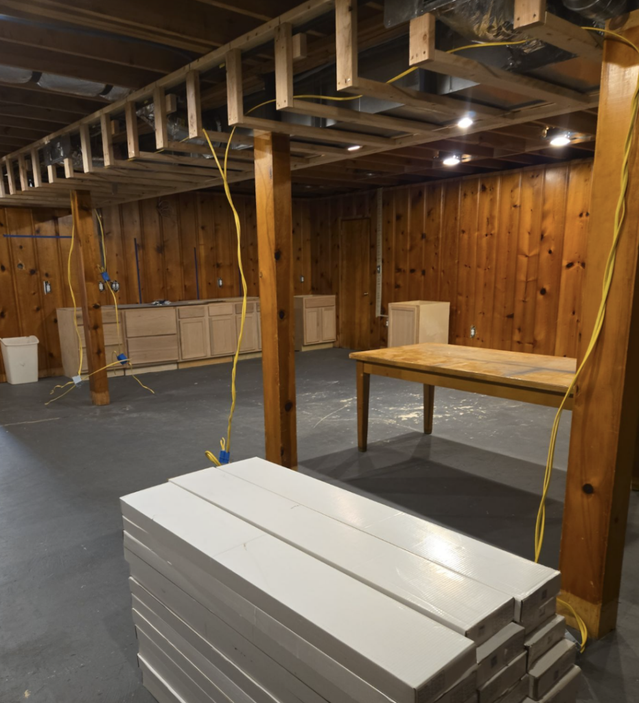 Basement remodeling in progress with custom cabinetry, exposed ceiling framing, and electrical rough-in for a luxury home renovation in Huntsville, AL.