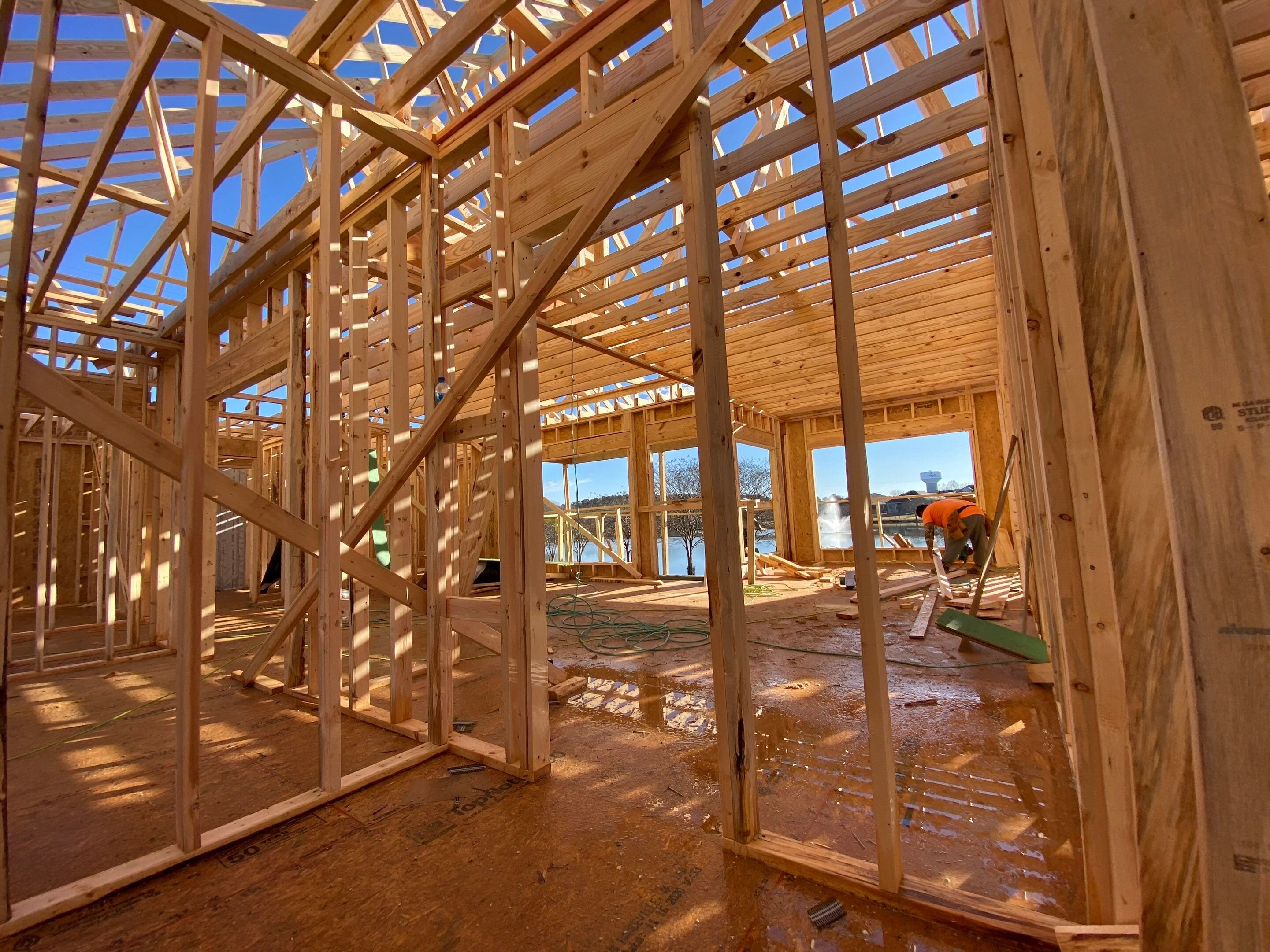 Luxury custom home under construction featuring engineered wood framing, open-concept layout, and expansive windows in Decatur, AL.