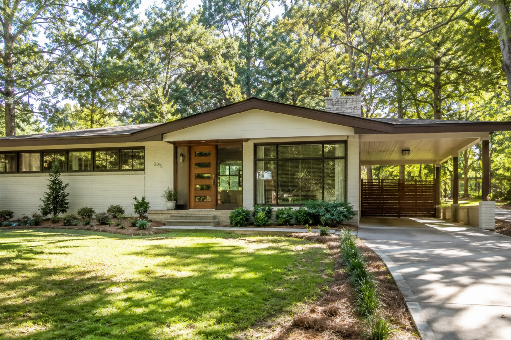 Modern mid-century ranch house with white painted brick exterior, large picture windows, covered carport, and professional landscaping in Southern Alabama.