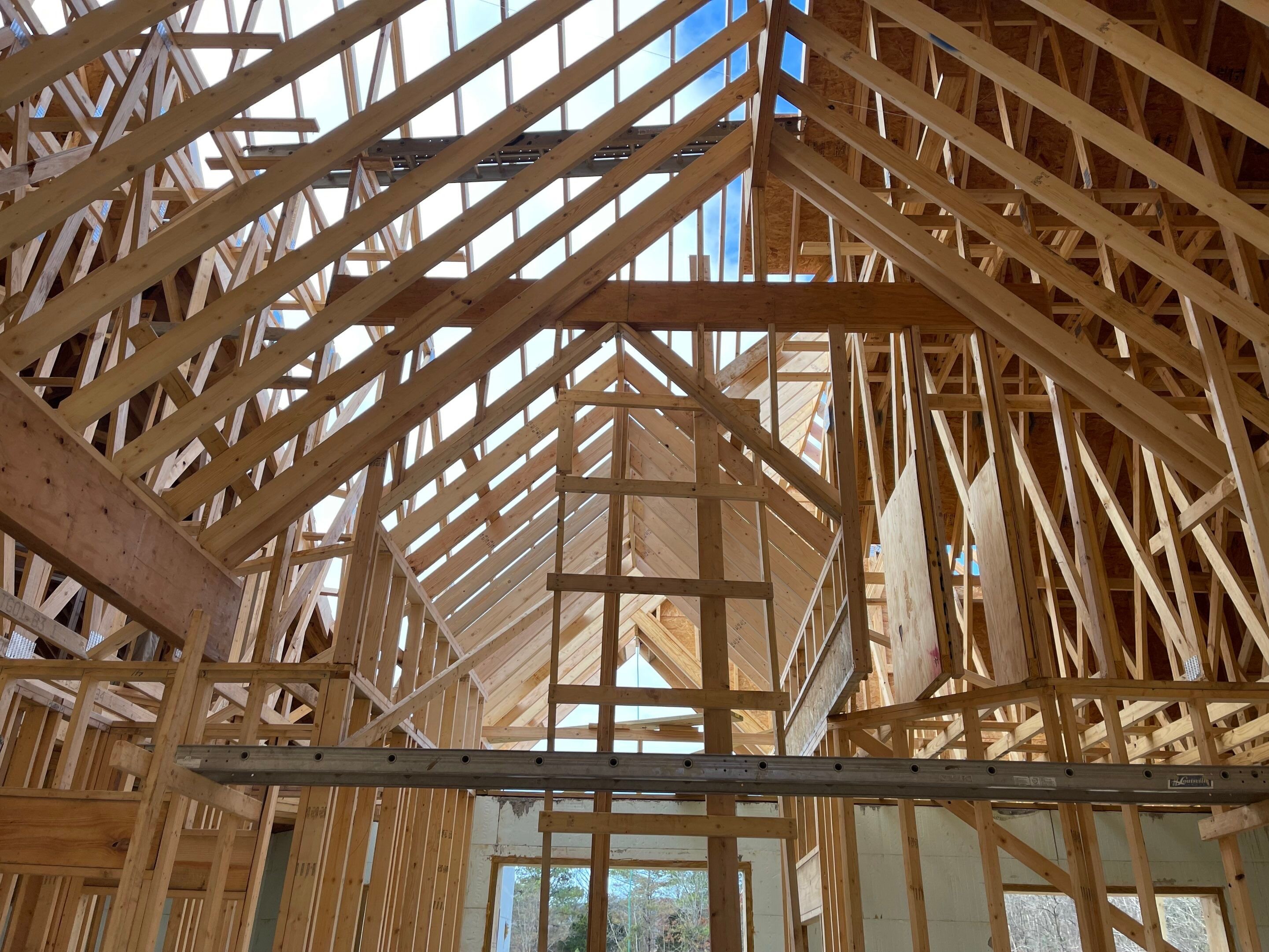 Vaulted ceiling framing with engineered roof trusses during luxury custom home construction in New Market, AL