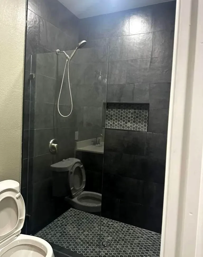 Modern bathroom remodel with walk-in shower and tile work by Mint Construction Pros in Texas