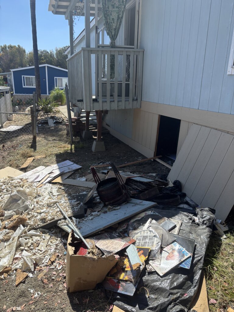 trash outside a mobile home in Vista CA