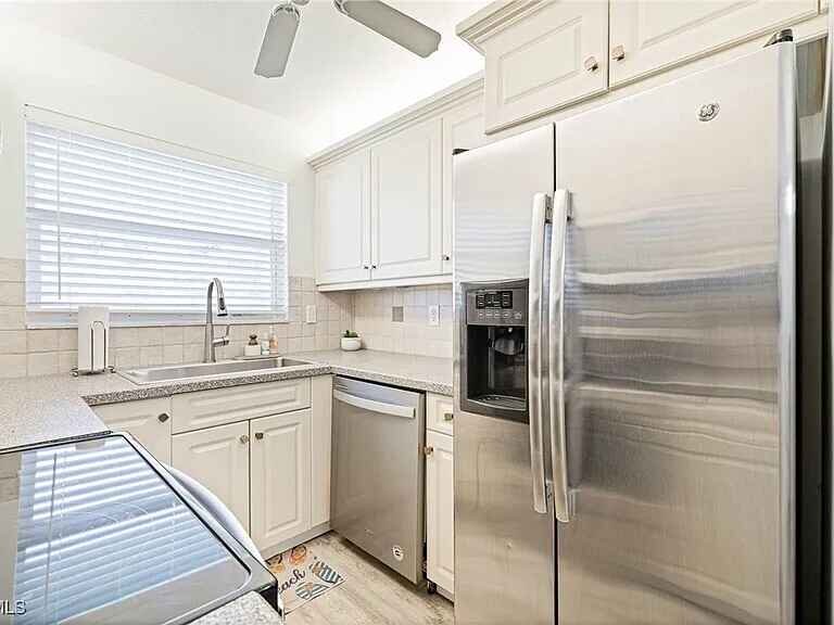 Kitchen with stainless refrigerator and dishwasher
