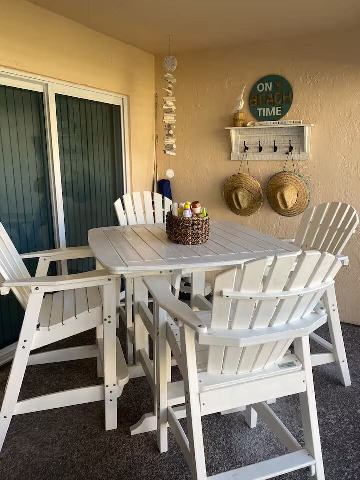 Screened patio dining table with white chairs