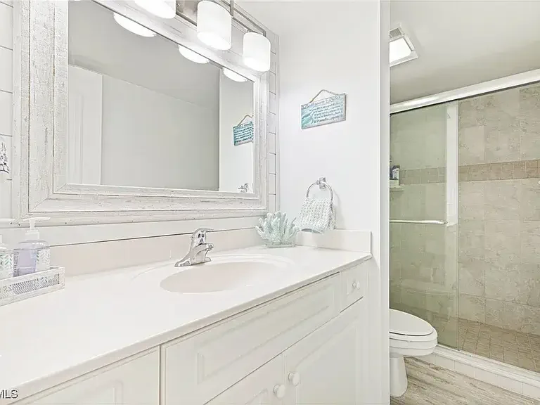 Bathroom with white vanity and glass shower