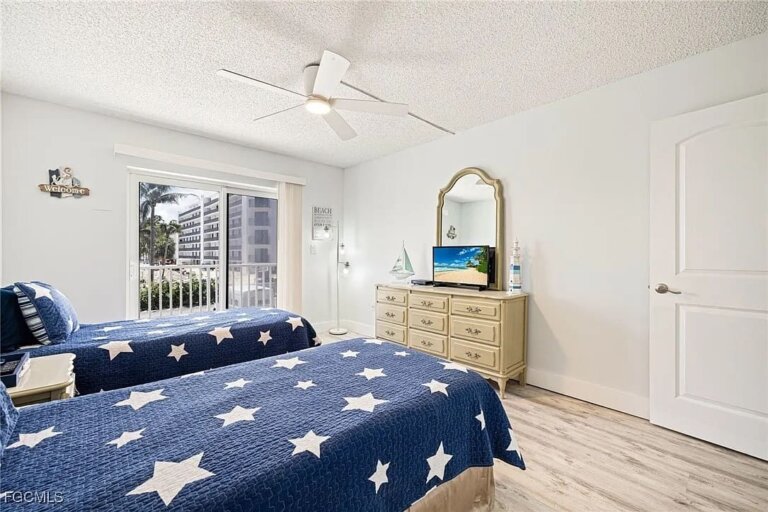 Twin beds with star quilts and a vanity dresser