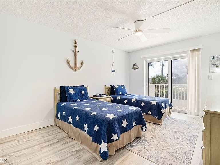 Twin bedroom with navy star quilts and anchor decor