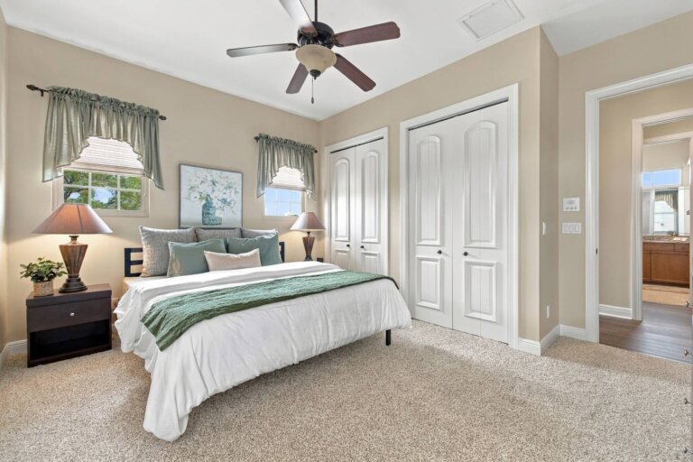 Guest bedroom with a queen-size bed, teal accents and a ceiling fan