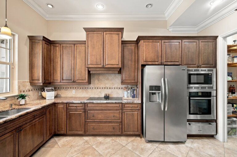 Kitchen with granite countertops, wood cabinets and a stainless steel refrigerator