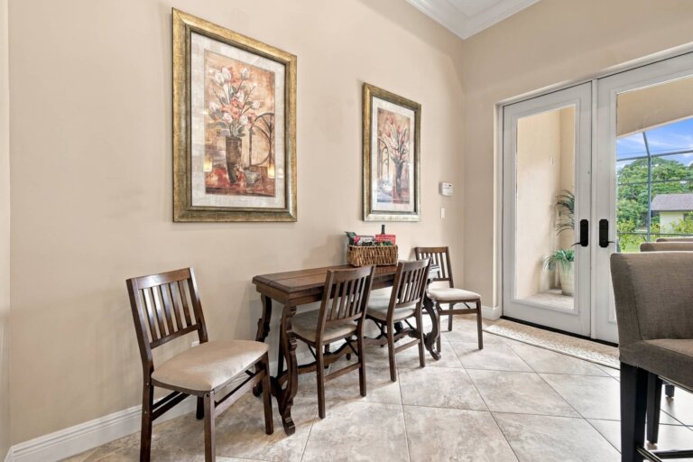 Breakfast dining area with a wood table, four chairs and framed artwork