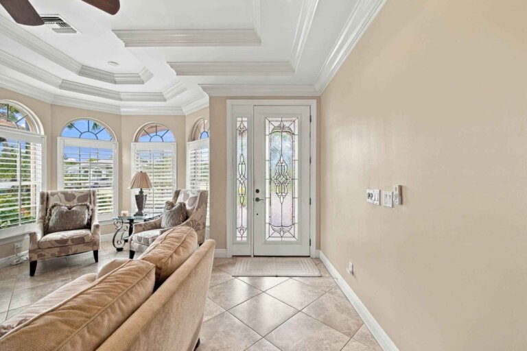 Entry foyer with a decorative leaded-glass front door and tray ceiling
