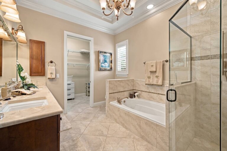 Primary ensuite bathroom with a soaking tub, glass-enclosed shower and vanity