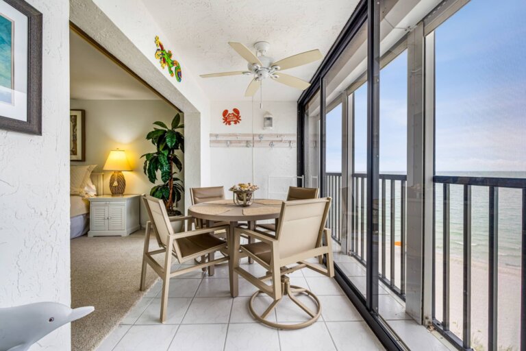 Indoor patio dining set beside sliding glass doors overlooking the water