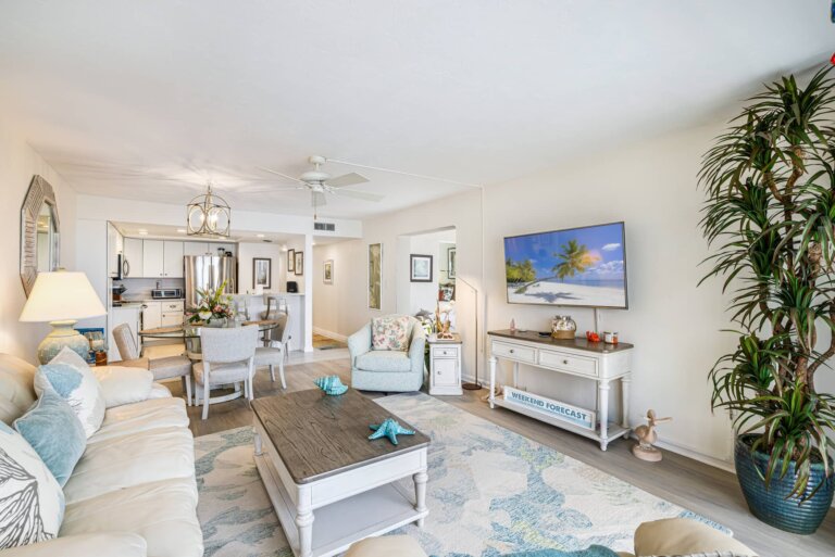 Living room seating with coastal decor and a wall-mounted TV