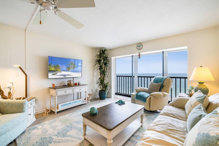 Bright living room with water views, a palm plant and coastal decor