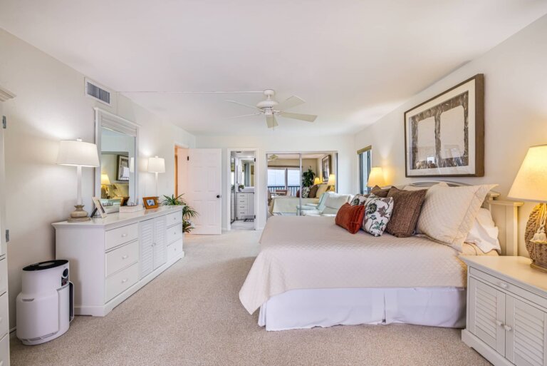Primary bedroom with a king bed and coastal artwork