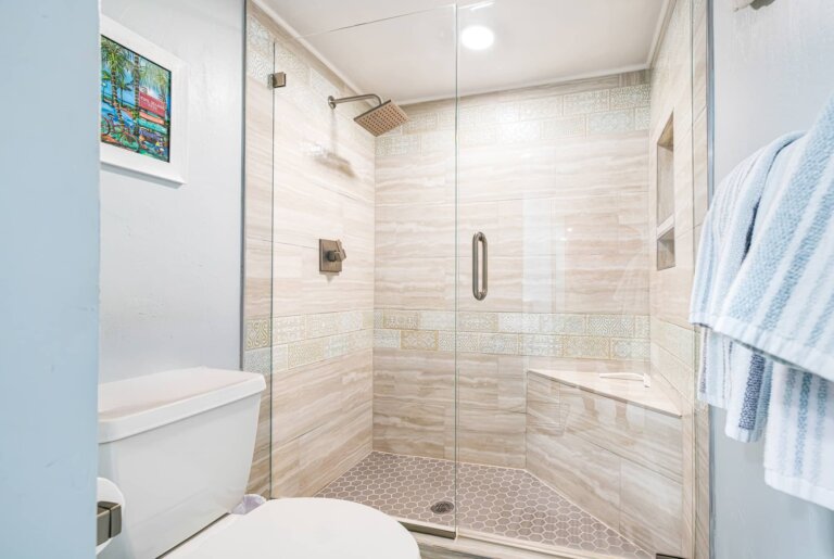 Walk-in shower with a glass door and tiled walls