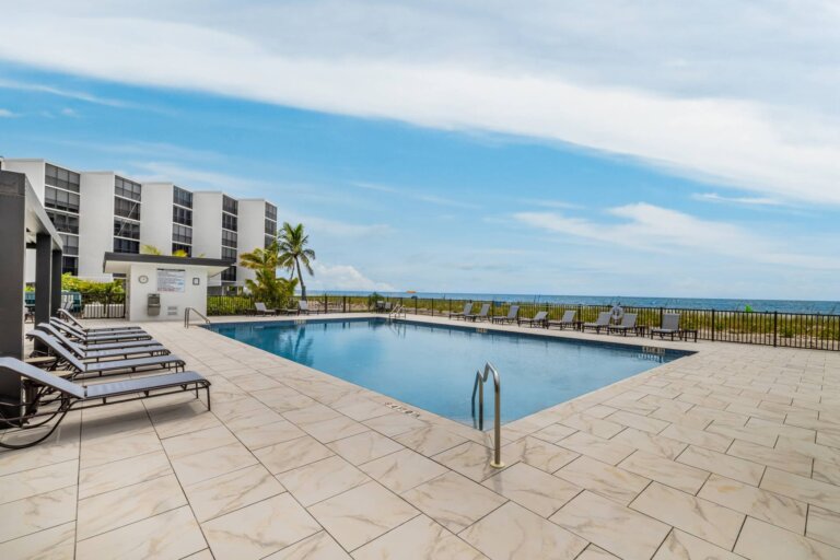 Gulf-front community swimming pool with lounge chairs at Seascape in Bonita Springs