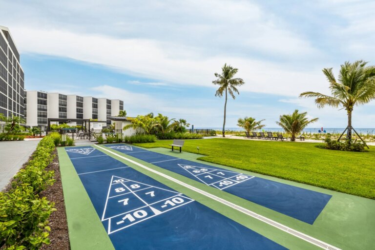 Community shuffleboard courts beside the lawn