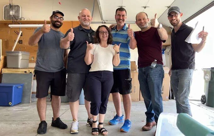 Ohio Cash Buyers team giving thumbs up in the garage