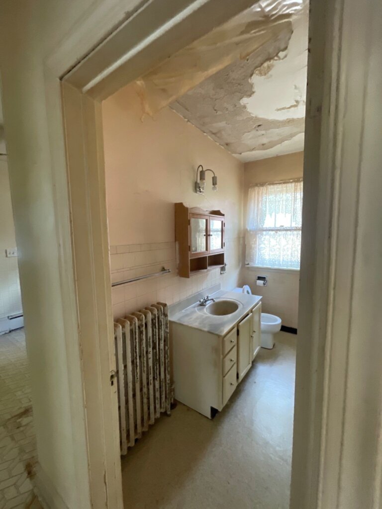Bathroom in a Lake County home with visible ceiling water damage before Greentown Home Buyers purchased it as-is