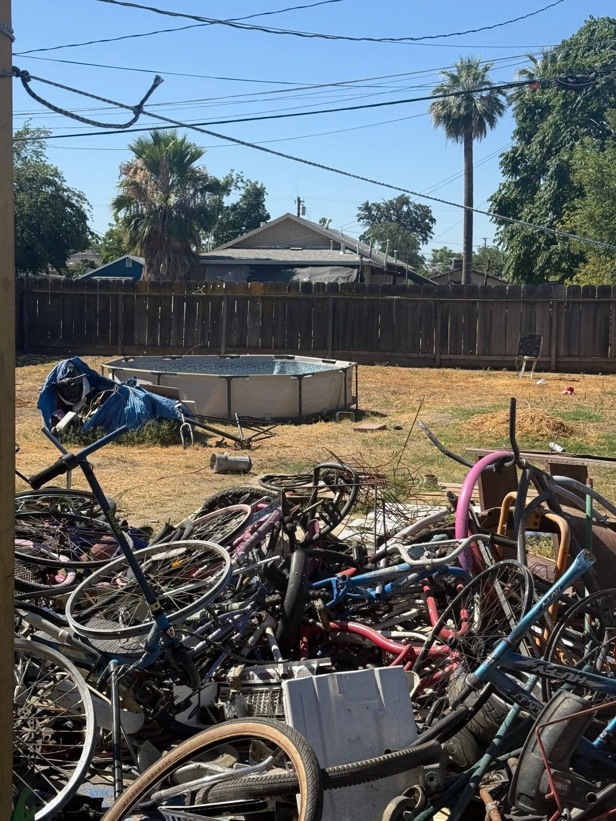 Backyard full of old bikes and junk at a Central Valley house sold as-is