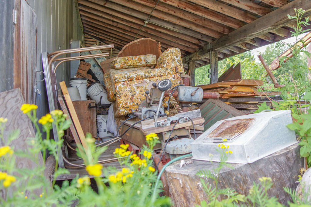 Piles of junk and old furniture under a covered patio