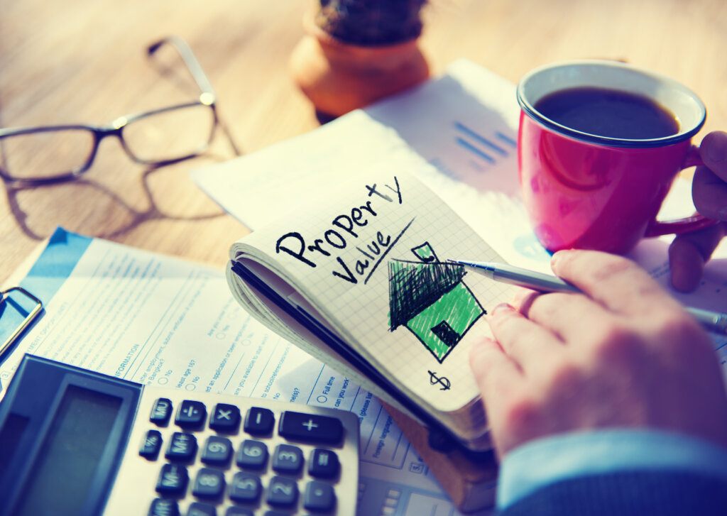 Notepad labeled Property Value next to a calculator and coffee