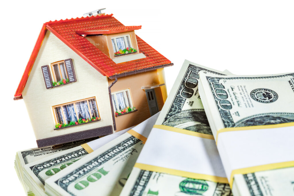 House model beside stacks of cash