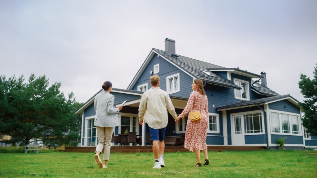 Family walking hand in hand toward a blue house