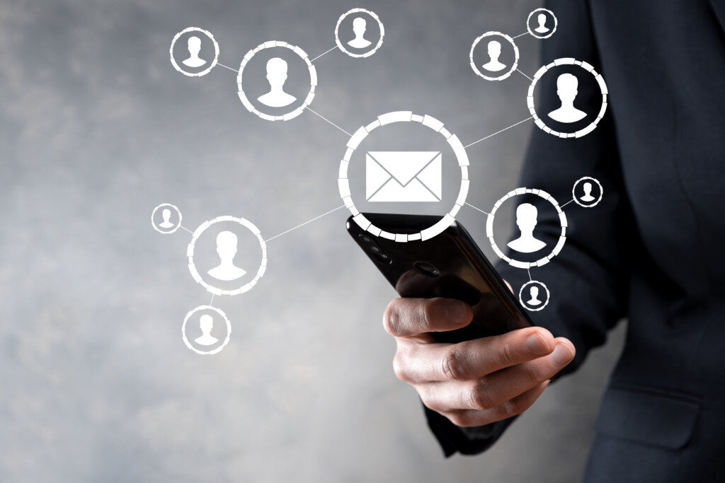 Hand holding a phone with email and contact icons