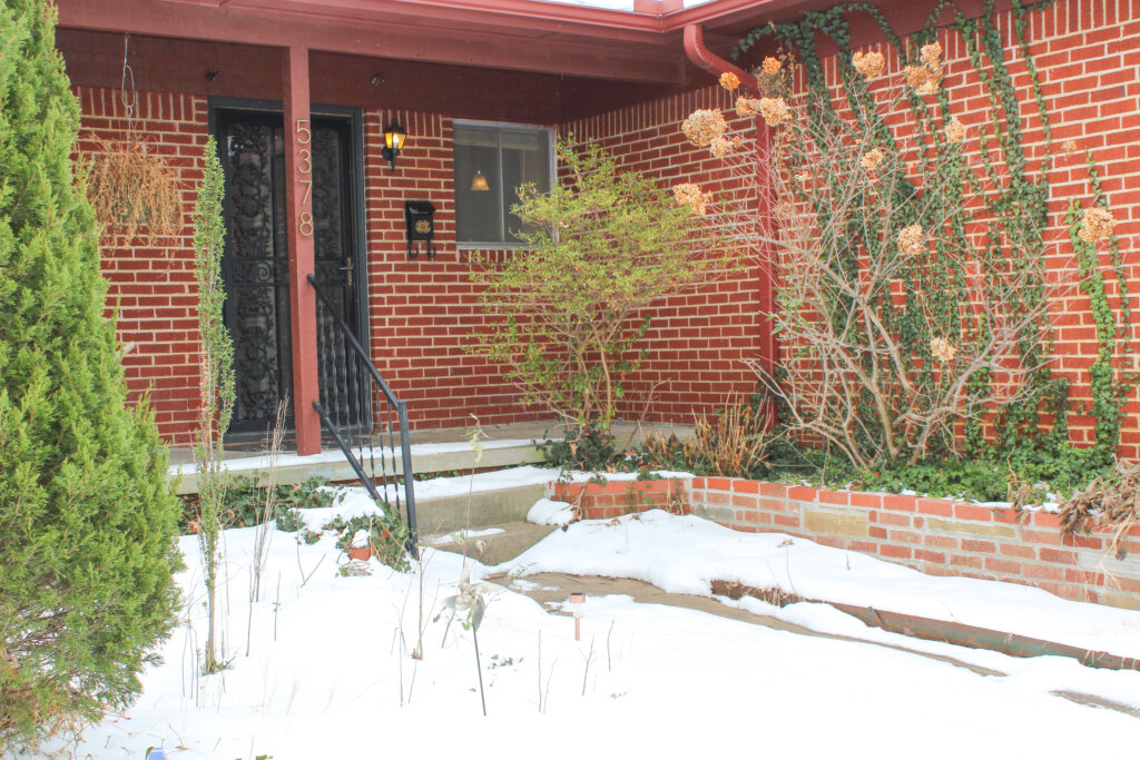 Brick home with a front porch after a snowfall