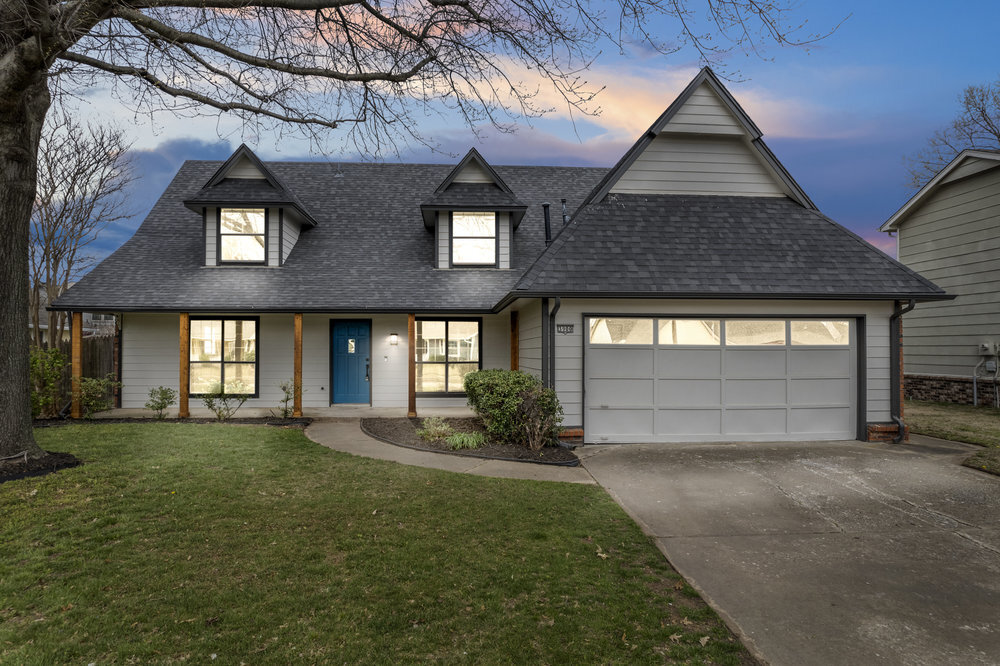 Gray two-story house with a two-car garage at dusk