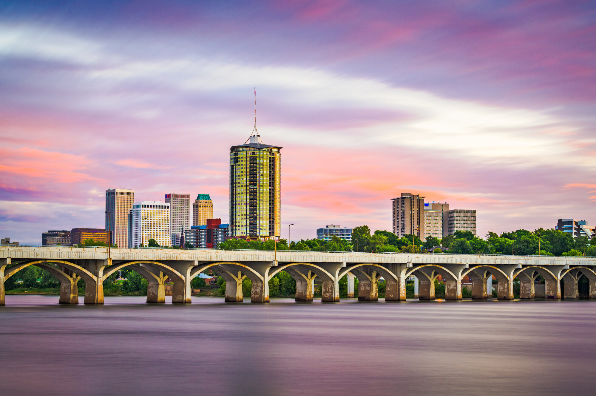 City skyline and a river bridge at sunset