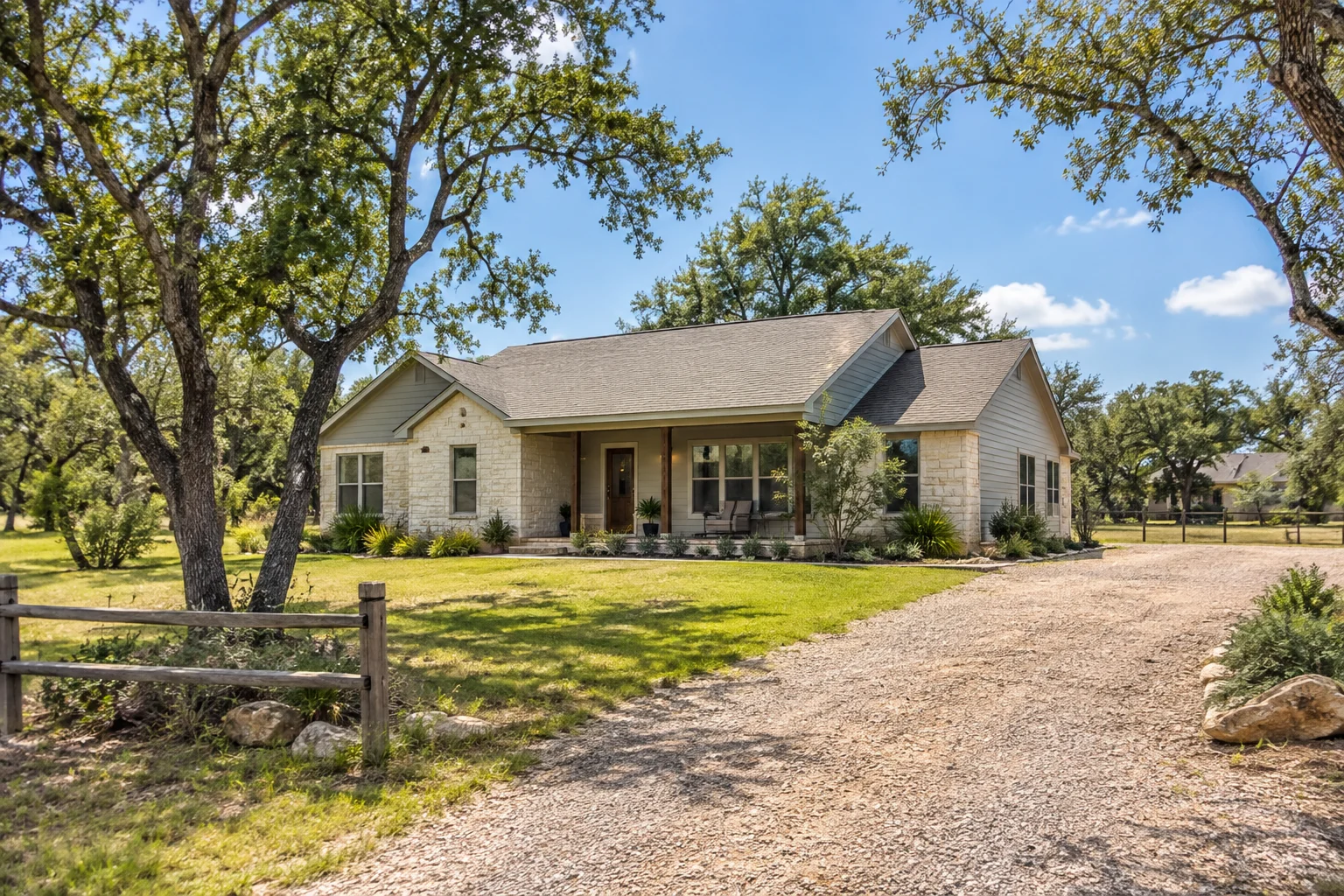 AI-generated illustration of a modest limestone home on an open residential lot with live oaks, a gravel drive and a neighboring home in the distance