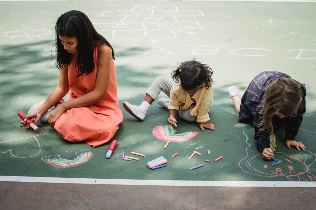 Children and Kinser Family Childcare childcare provider drawing chalk pictures on pavement