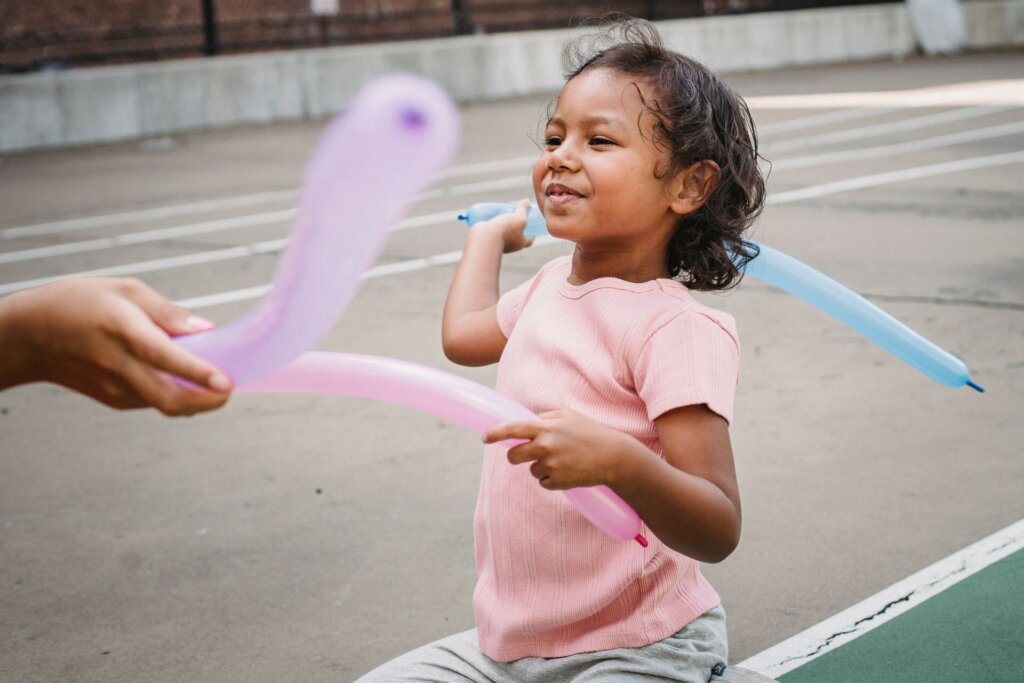 Child playing with balloons outside