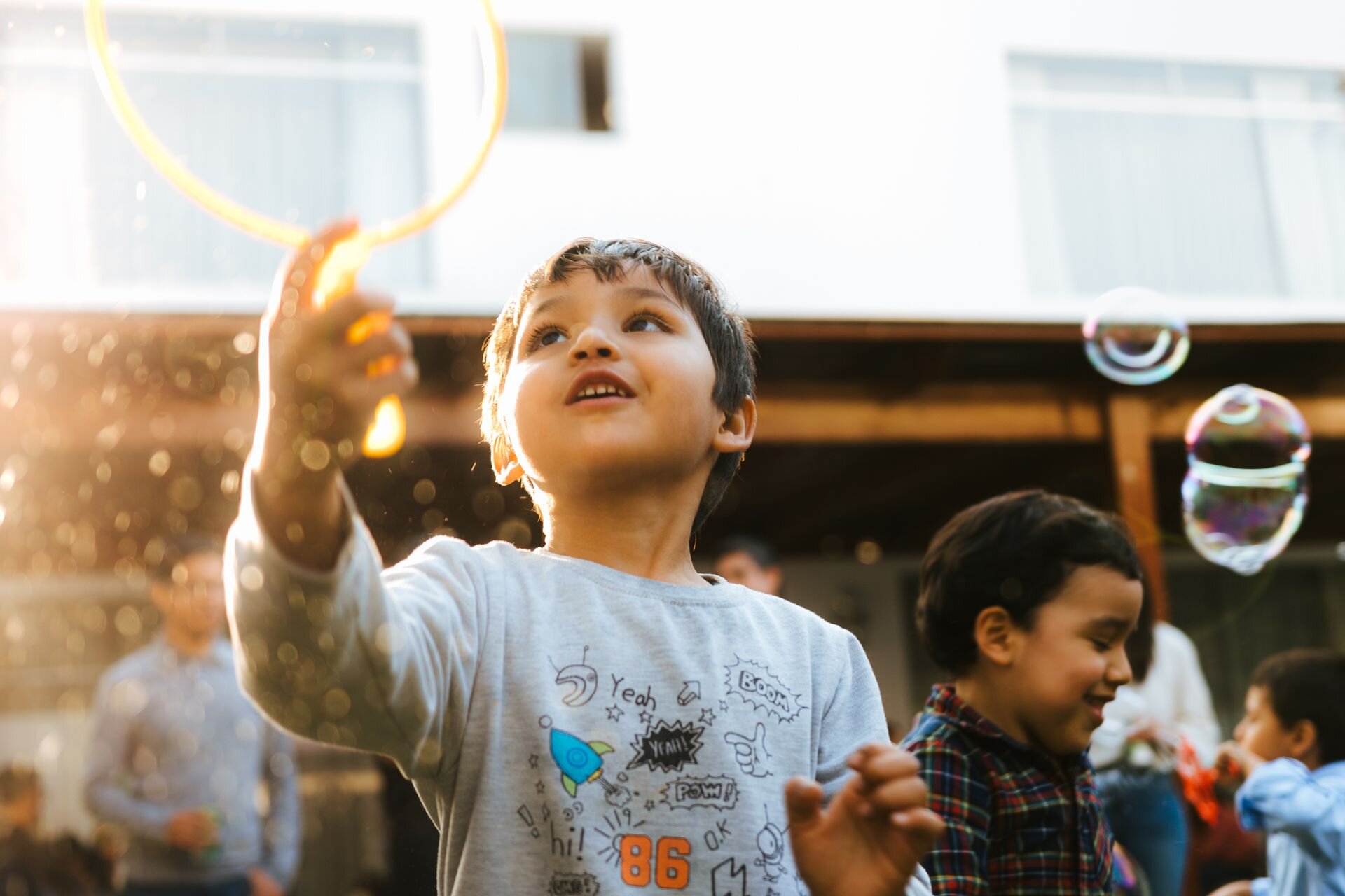 Two young boys outside with bubble wands